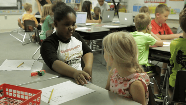 Two middle school girls doing math work in a classroom